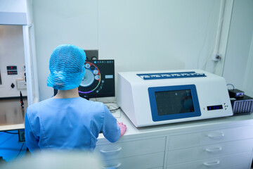 Lab technician working with incubator and monitoring embryo development