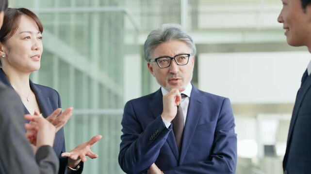グループの中で一人で悩む男性ビジネスパーソン