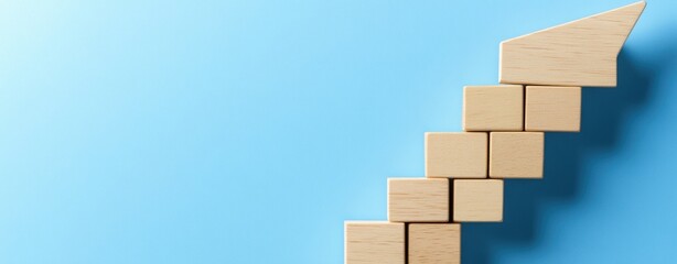 Fototapeta premium Wooden Blocks Forming an Arrow on a Blue Background
