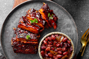 Roasted Pork Ribs in BBQ Sauce with Red Beans in the plate close up
