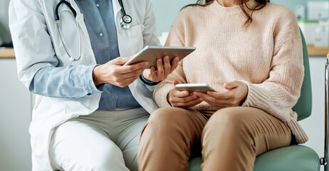 Doctor is showing medical information on a tablet to her patient who is holding a smartphone. High quality photo