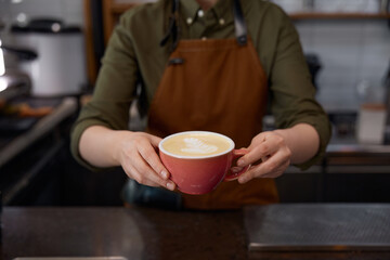 Barista serving client giving freshly brewed cappuccino or latte