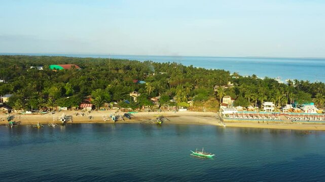 Tropical island with fishing boats over the blue sea. Sandy beaches in coastal area in Bantayan Island. Kota Park in Cebu. Philippines.