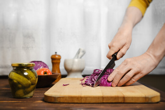 Unrecognizable man cutting red cabbage - Powered by Adobe