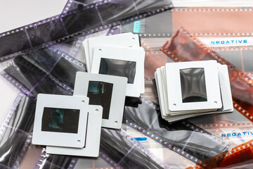 A pile of slides on top of colour, and black and white film negatives.
