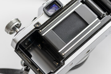 Close up of the opened back of a vintage photography camera where film rolls are loaded.