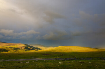 Beautiful Green Field Green Hills, Storm and sun contrast weather. Photo nature Background