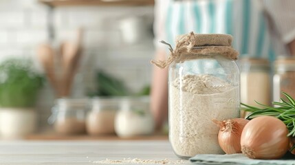 A jar of onion powder open on a rustic kitchen counter.