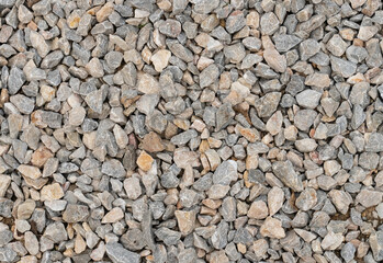 gray stone background of many small cobblestones, pebbles river bank