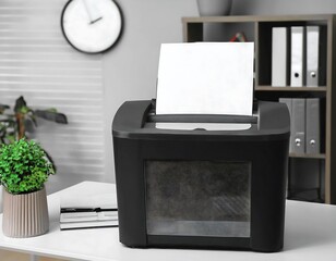 Paper shredder with bin on white table in office
