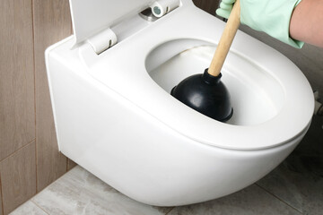Close-up of the process of unclogging a toilet with a plunger