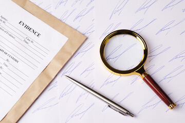 Forensic handwriting analysis concept, samples of fictitious signature on sheets of paper, magnifying glass and envelope for evidence