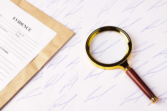 Forensic handwriting analysis concept, samples of fictitious signature on sheets of paper, magnifying glass and envelope for evidence