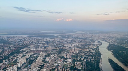 A panoramic aerial view of a sprawling city with rivers and green spaces, representing urban development issues