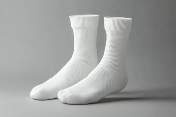 A pair of clean, white socks displayed on a neutral background, highlighting their design and texture.