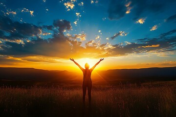 Fototapeta premium Woman raising arms to sunset in grass field