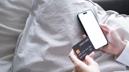 Close up female hands holding credit card and smartphone, young woman paying online, using banking service, entering information, shopping, ordering in internet store, doing secure payment