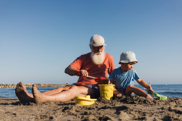Grandfather and Grandson Building Sandcastles Together