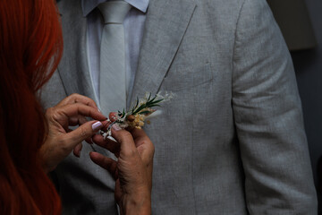 Mujer no reconocible pone prendido de novio o boutonnière, España