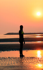 Woman in swimsuit against the light and the sun behind her with unrecognizable face