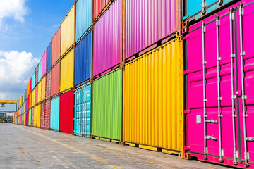 Fototapeta premium A vibrant display of shipping containers in various colors, stacked neatly at a port, showcasing industrial transport.