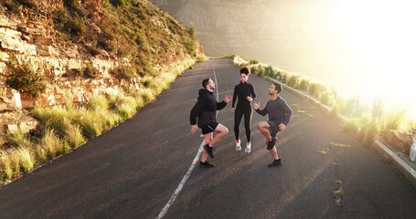 Fototapeta premium Fitness, friends and warm up on road for exercise, training and running preparation. People, jog on the spot and cardio on mountain asphalt for wellness, coaching and muscle development in challenge