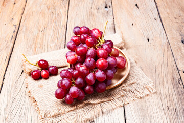 Red grapes on old wooden table background