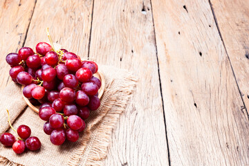 Red grapes on old wooden table background