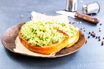 Traditional mexican sauce guacamole on bread.