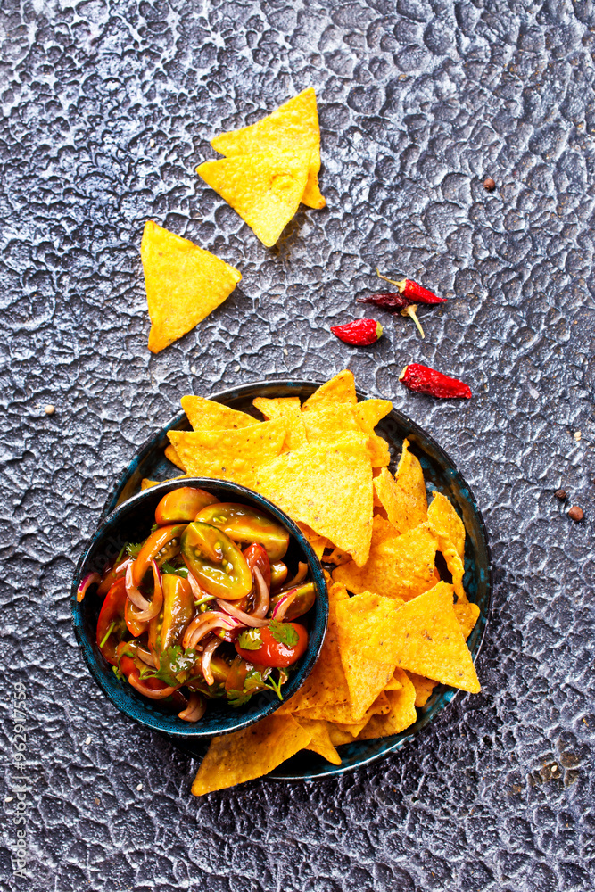 Canvas Prints Single big black plate of yellow corn tortilla nachos chips with salsa sauce