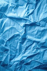 Fototapeta premium Crumpled blue paper texture background with creased surface. Close-up view of folded and wrinkled material on white background. Ideal for design projects, creative work, and artistic expressions.