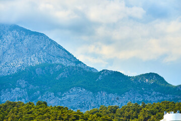 The stunning beach features mountains and a resort, ideal for travel and leisure themes that...