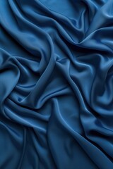 Fototapeta premium Blue fabric texture pattern close-up view. Crumpled silk or satin material folded to create depth and dimension. Overlapping folds form intricate design. Blurred background focuses on fabric details.