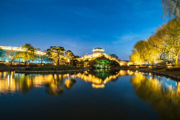 Paldal-gu, Suwon-si, Gyeonggi-do, South Korea - April 1, 2021: Night and illumination view of Yongyeon Pond with reflection of Banghwasulyujeong pavilion at Suwon Hwaseong Fortress