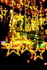 Twinkling golden star-shaped lights hang against a backdrop of warm bokeh, creating a magical holiday atmosphere for the Christmas season. Matte mask background.