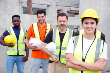 Engineer wearing safety helmet standing smiling at construction site.
