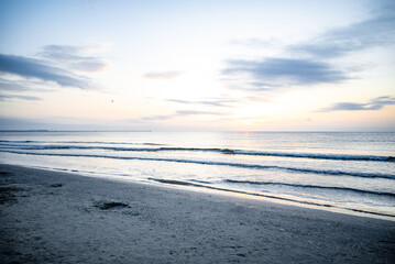 Tranquil ocean sunrise with calm waves and clear sunrise sky - amazing coastal scenery