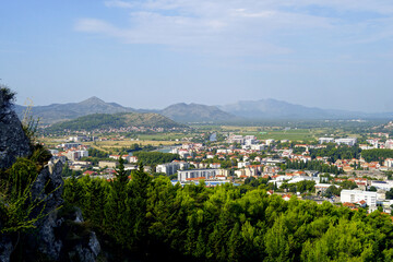 Fototapeta premium Aerial view of Trebinje: a city located in a river valley surrounded by mountains. Cities of Bosnia and Herzegovina: panoramic view of Trebinje from the Hercegovacka Gracanica Monastery.