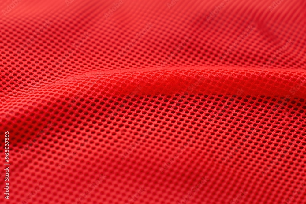 Poster Red fabric with unique texture, small square holes create grid pattern. Possibly synthetic, durable and wrinkle-resistant. Elevated angle reveals intricate design.