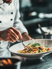 A chef is preparing a plate of food with a fork