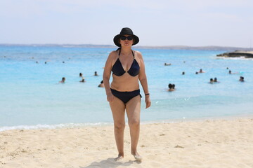 adult woman in swimsuit relaxing on the seashore