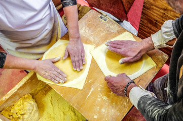 Basque farmers (Baserritarras) making Talos, a Basque tortilla stuffed with fresh chorizo called Txistorra, at the Santo Tomas Fair, served as traditional street food during the Day of Saint Thomas.