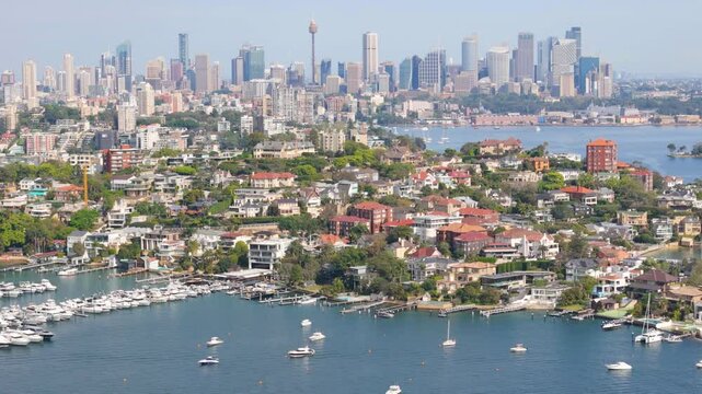 Aerial drone view of the suburb of Point Piper in East Sydney, NSW, Australia in September 2024 showing Sydney City large and prominent in the background with lens compression techniques 