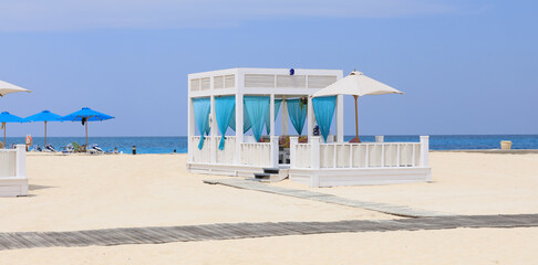 seaside resort beach with white sand and a gazebo for relaxation