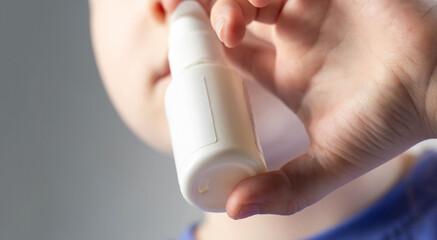 A caucasian girl puts drops into her nose and an anti-inflammatory spray for nasal congestion. Treatment of runny nose and sinusitis. Antibiotic medicinal spray, close-up