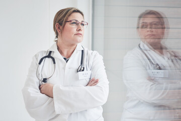 Window, thinking and woman with arms crossed, doctor and glasses with idea for healthcare. Person, medical and professional with solution, career ambition or specialist with thoughts, pride or wonder