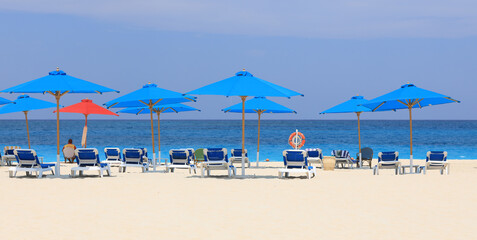 seaside resort beach with white sand and sun umbrellas