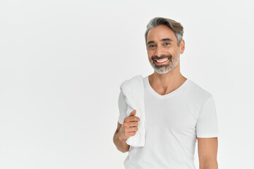 Happy middle aged man holding shower towel isolated on white studio background. Smiling mature handsome bearded gray-haired male model wearing t-shirt looking at camera. Portrait.