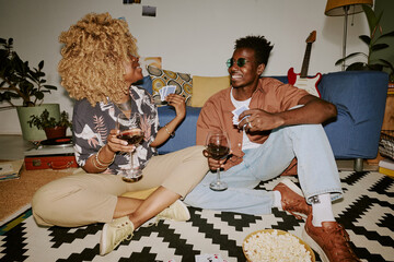 Young man and woman having fun together, they drinking wina and chatting