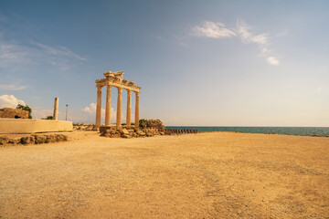 Naklejka premium The ancient Temple of Apollo ruins in Side, Turkey, standing majestically by the Mediterranean Sea. The image captures the iconic columns of the temple against a backdrop of a clear sky